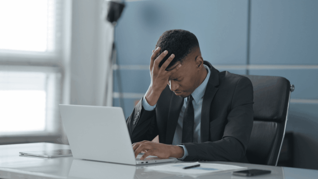 Young Businessman having Headache while Working on Laptop